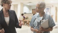 Two people walking through a healthcare facility