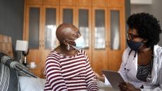 A cancer patient talking to a provider in her home. 
