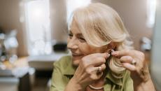 Person putting a hearing aid in their ear