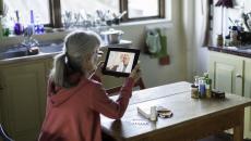 An older person talking to a provider through a video chat on a tablet.