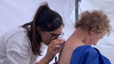 A nurse conducting a skin check using AI in a pop-up clinic
