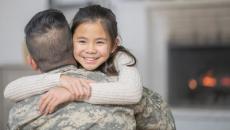 Military serviceman hugging another person 