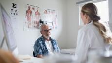 A senior patient in an in-person consultation with a doctor in a clinic