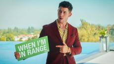 Nick Jonas pointing to a green sign that says "When I'm in range"